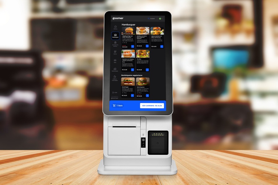 Self-service kiosk de restaurante com tela display interativa mostrando opções de hambúrgueres e sistema de pagamento, ideal para pedidos rápidos e eficientes.