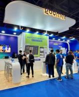 Visitantes na feira de tecnologia interagindo com sistemas de autoatendimento no espaço de autoatendimento de um evento de tecnologia, destacando inovação e atendimento ao cliente.