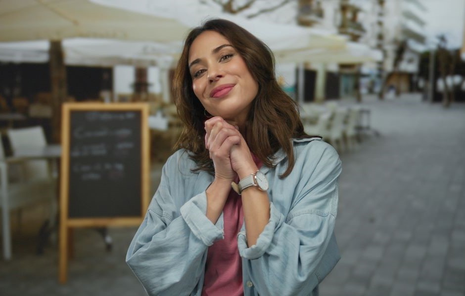 Mulher sorridente na rua, vestida casualmente, demonstrando felicidade e autoestima, com cenário urbano ao fundo, perfeito para ilustrar autoestima e bem-estar.