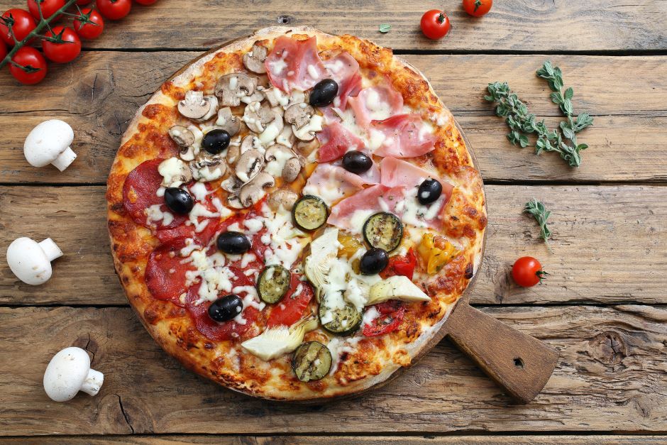 Pizza quattro stagioni em uma recipiente de madeira sobre uma mesa 