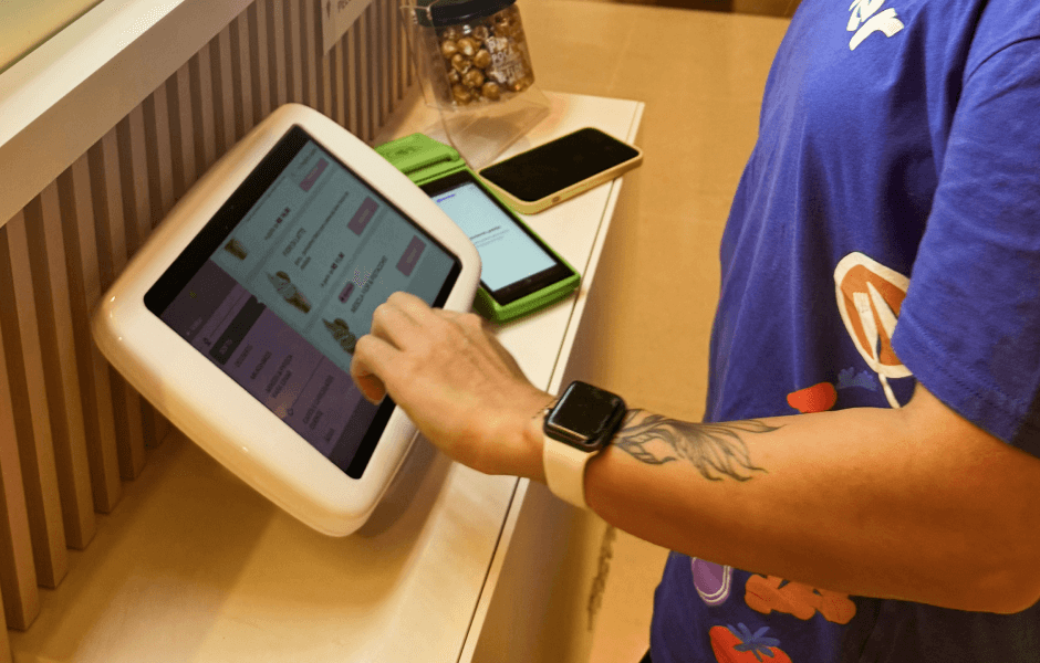 Pessoa utilizando um totem em um ambiente de restaurante, interagindo com um sistema digital de pedidos.